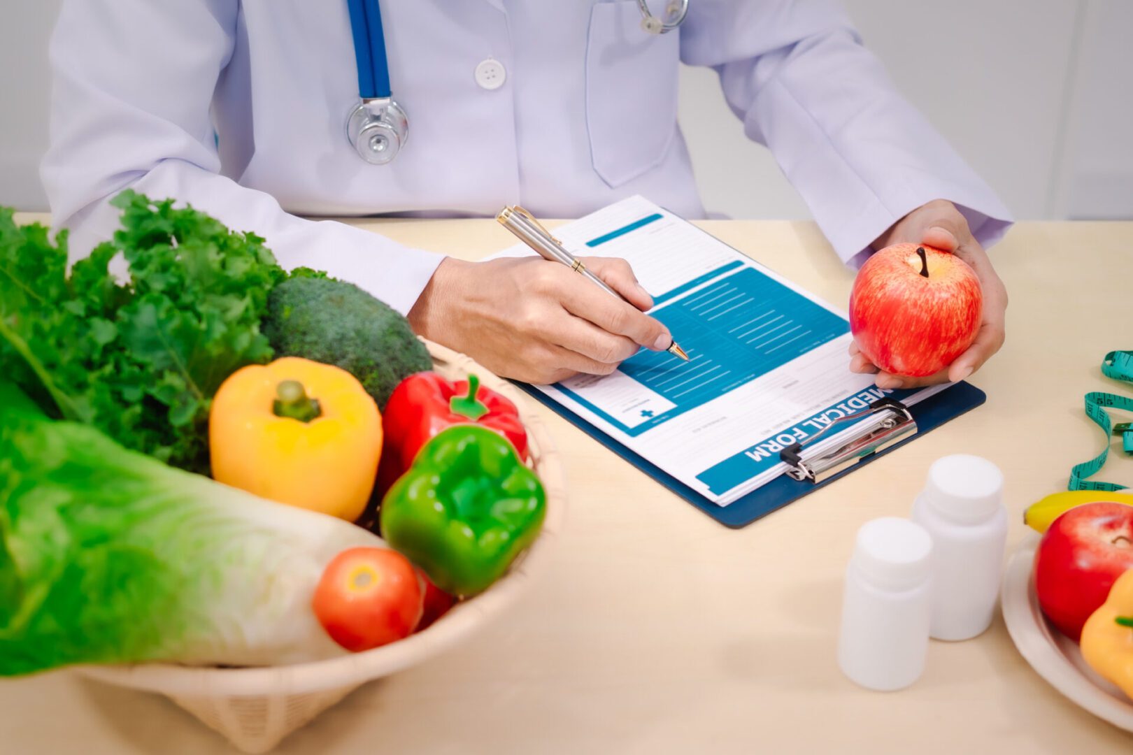 Nutritionist writing notes with vegetables nearby.
