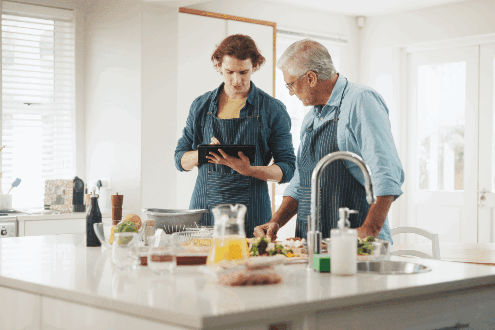 Two men cooking together in kitchen.